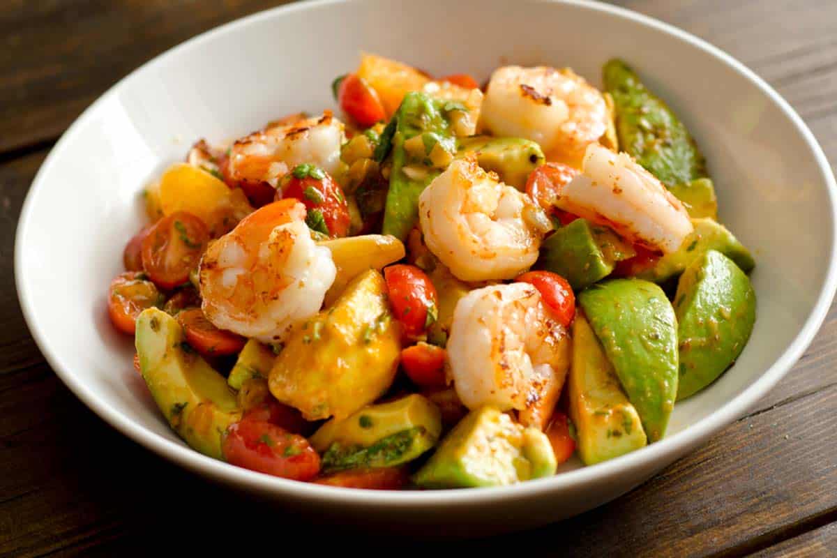 white bowl filled with Shrimp salad with avocado and orange