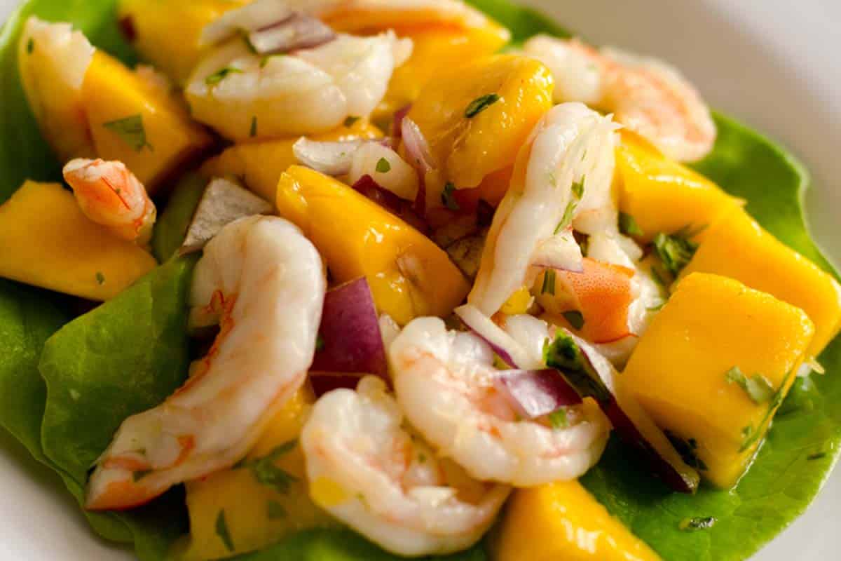 closeup of a white plate with a serving of Shrimp and mango salad with pineapple vinaigrette