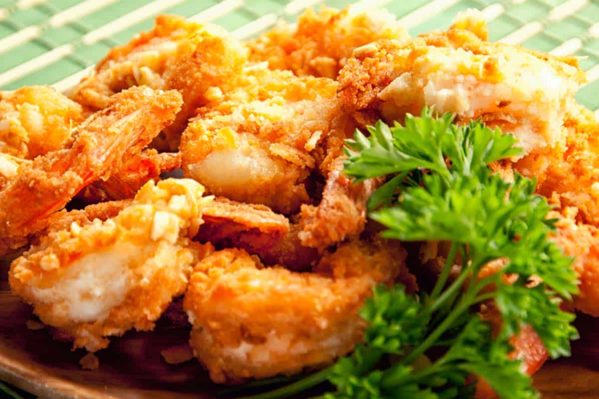 plate full of almond and coconut fried shrimp with parsley