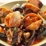 mussels and clams in tomato sauce served in a bowl