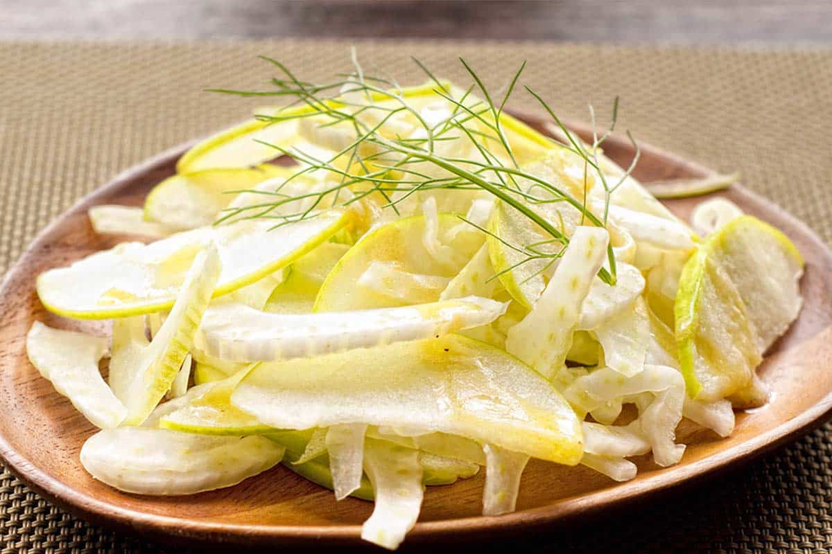 wood plate filled with sliced apples as a Apple and fennel salad