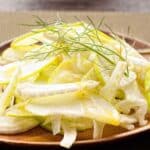 sliced Apple and fennel salad on a wooden plate