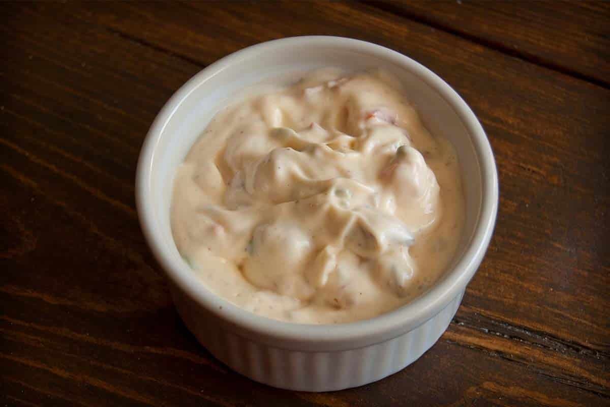 overhead view of Bacon & Mayonnaise Dip in a ramekin on a wood table