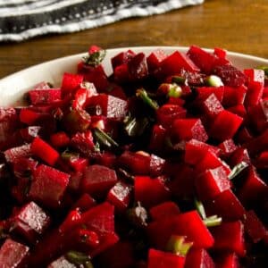 closeup of a bowl full of Beetroot salsa on a wood table