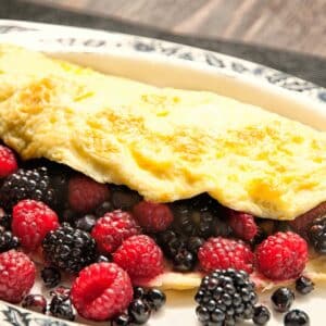 closeup of a Berry Omelet with blackberries and raspberries spilling out