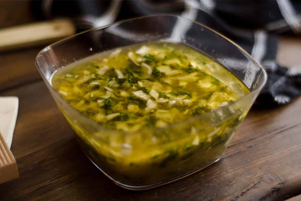 Brazilian chicken marinade in a glass square bowl on a wood table