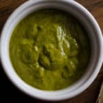 closeup of a ramekin full of Chermoula wet rub on a wood table