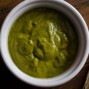 closeup of a ramekin full of Chermoula wet rub on a wood table