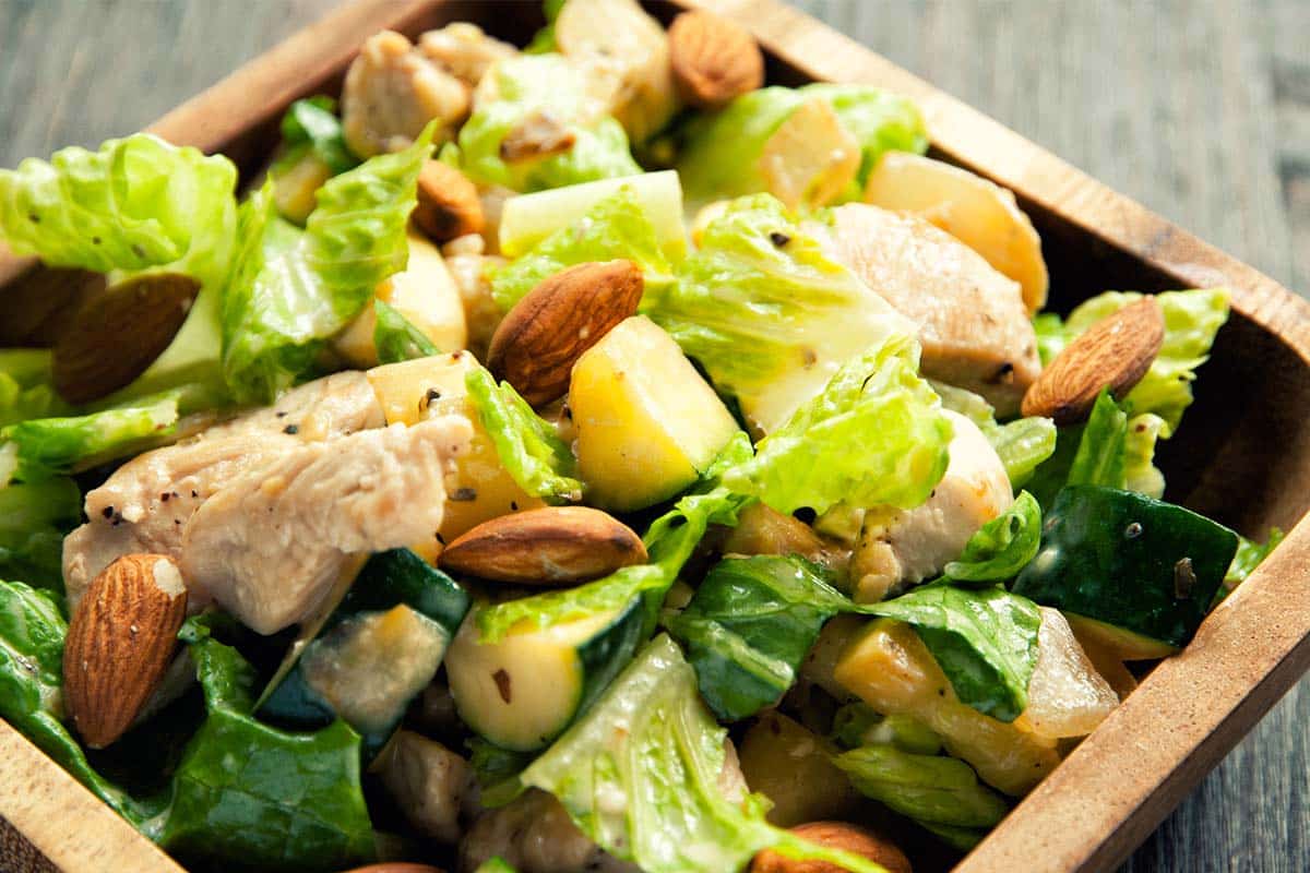 wooden bowl filled with Chicken and zucchini hot salad 