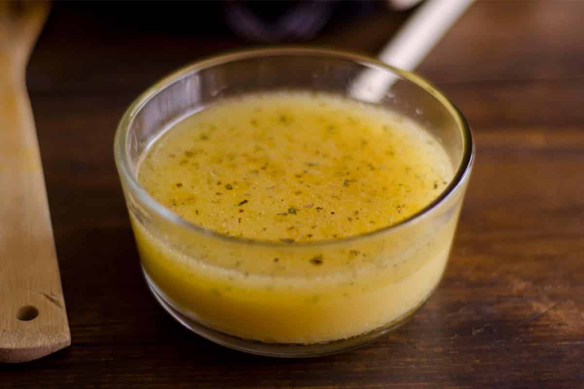 Chicken apple cider vinegar marinade in a glass bowl on a wood table