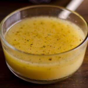 glass bowl filled with Chicken apple cider vinegar marinade on a wood table