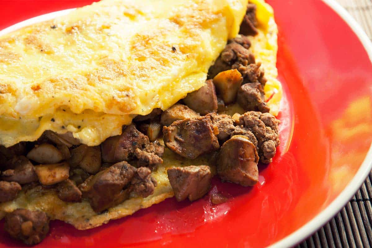 Chicken liver omelet on a red plate