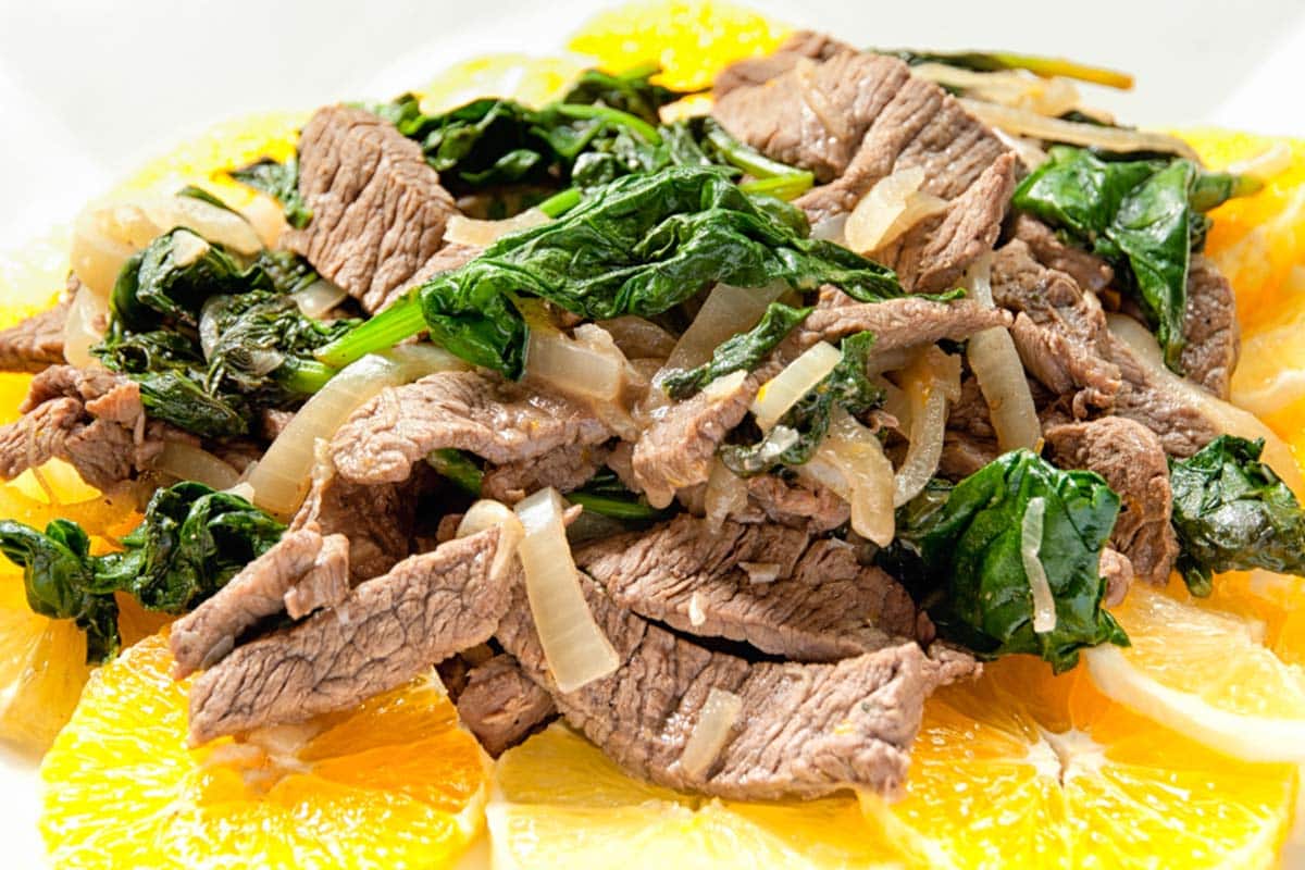 closeup of a white plate with a serving of Citrus beef salad stir-fry