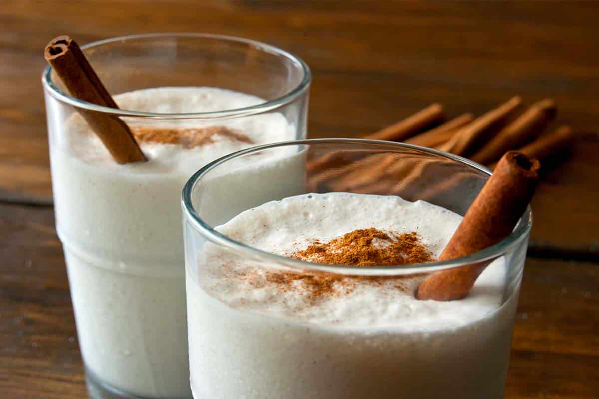 Coconut vanilla milkshake in two glasses with cinnamon sticks