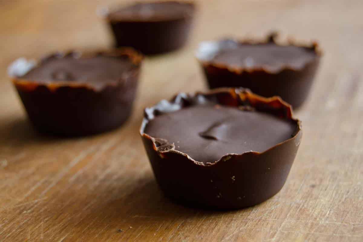 four Dark Chocolate and Almond Butter Treats on a wood table