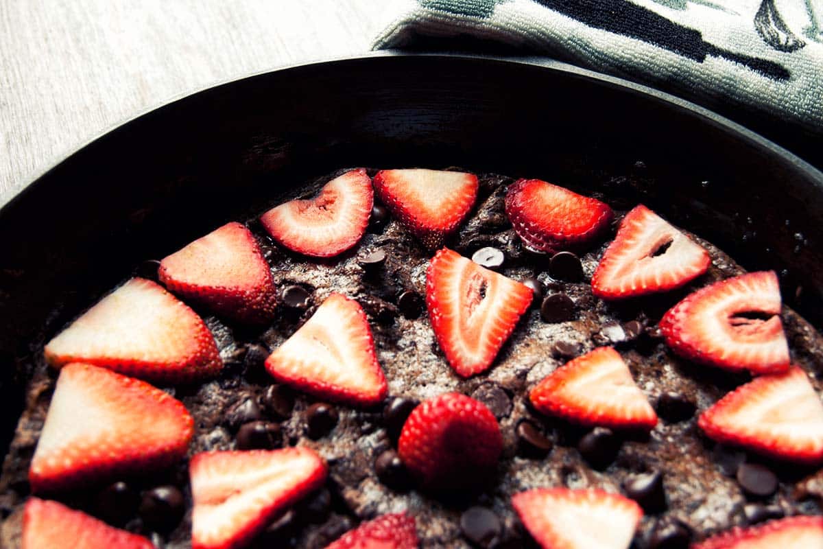 closeup of a pan of dark chocolate frittata with strawberries