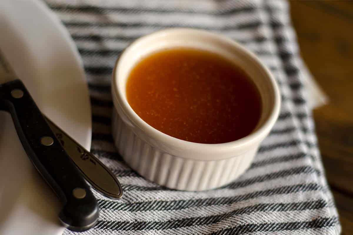 overhead view of Eastern North Carolina BBQ sauce in a small ramekin with a plate and silverware