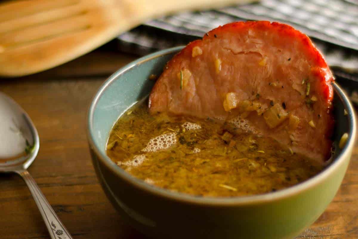 blue bowl filled with French Onion Soup with Baked Ham on a wood table