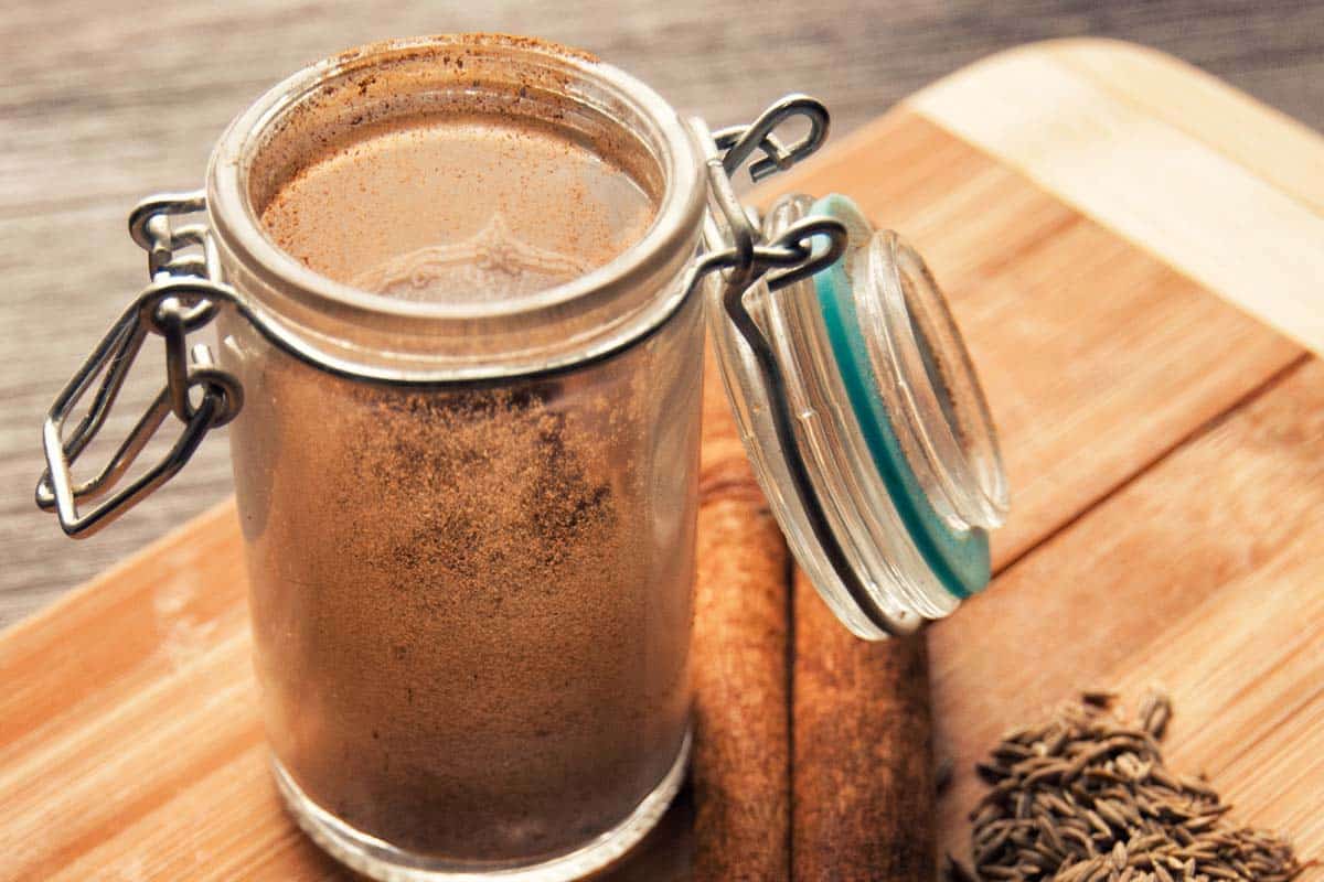 open jar of Garam Masala on a wood cutting board