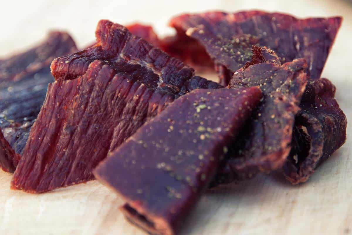 closeup of Herb Flavored Beef Jerky on a wood table