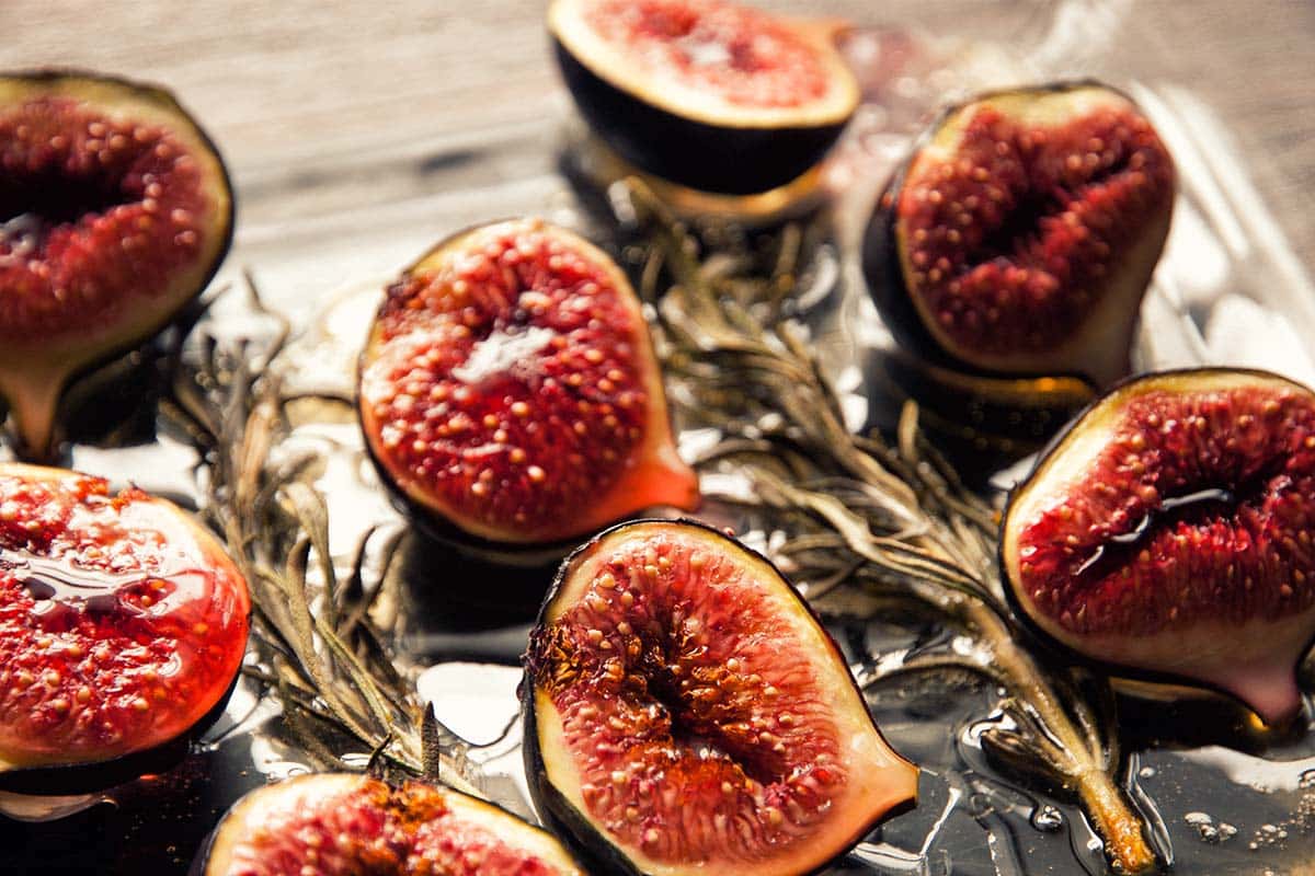 closeup of a glass serving tray filled with Honey-rosemary roasted figs