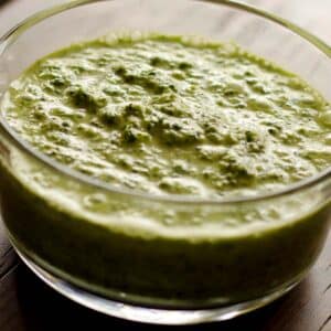 closeup of a glass bowl full of mojo marinade on a wood table