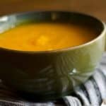 closeup of a green bowl with a serving of Pumpkin soup