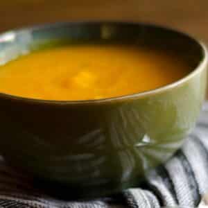 closeup of a green bowl with a serving of Pumpkin soup