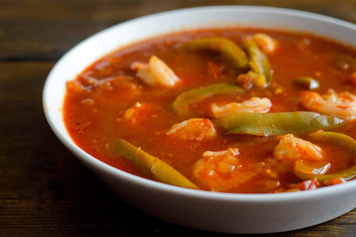 closeup of Shrimp gumbo in a white bowl on a black table