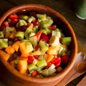 closeup of a wood bowl filled with Simple fruit salad