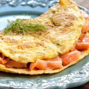 Smoked Salmon Omelet on a light blue plate with a sprig of green garnish
