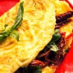 red plate filled with Sun-dried tomato omelet
