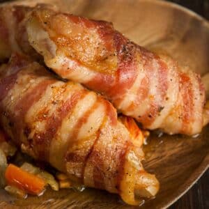 closeup of Sweetbreads with bacon on a wood serving tray