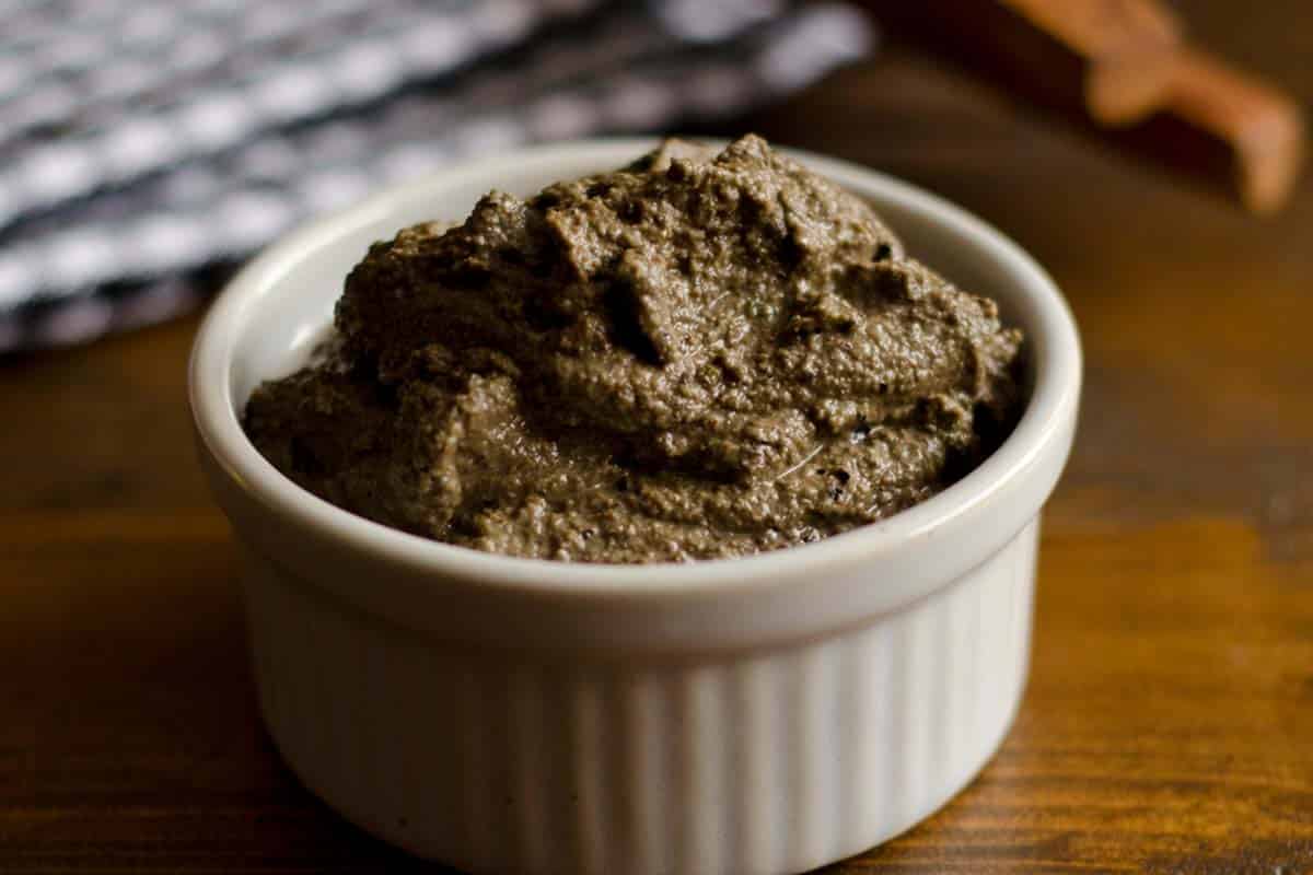 Tapenade in a ramekin on a wood table