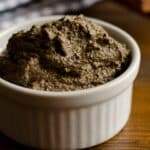 white ramekin full of Tapenade on a wood table