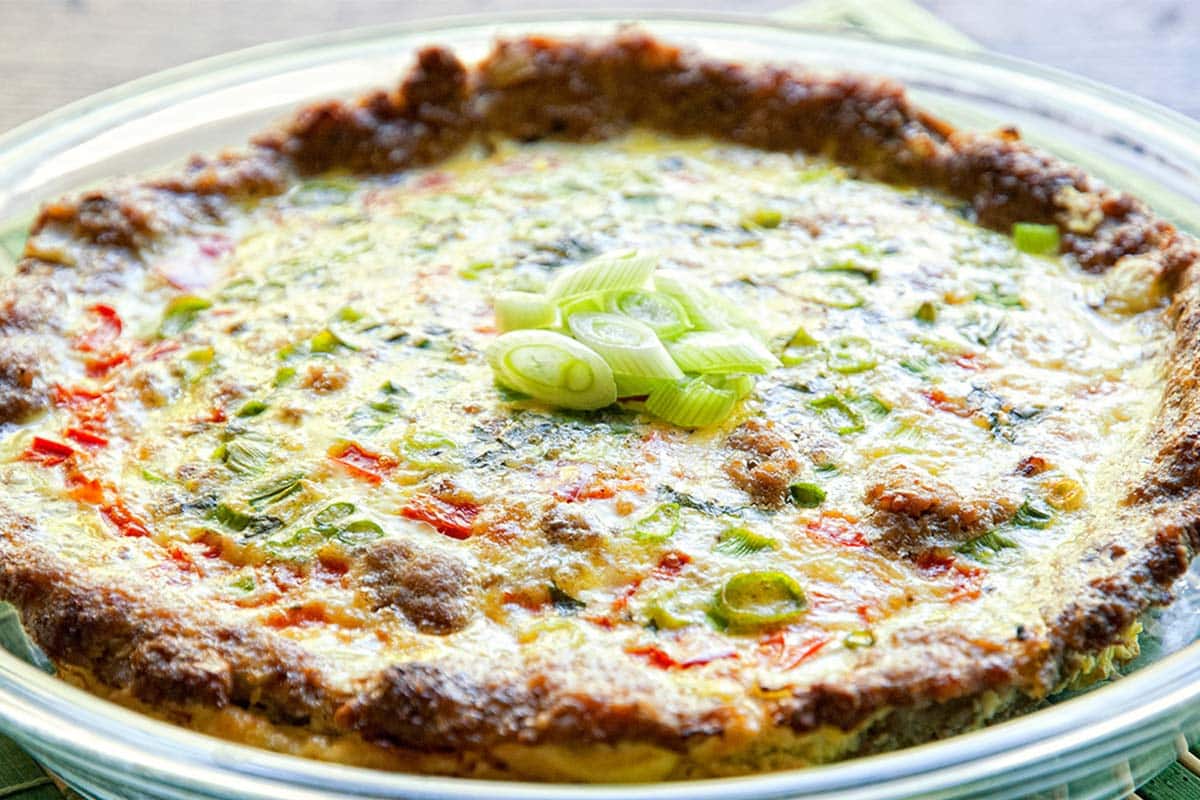 plate filled with omelet with sausage crust served open-faced